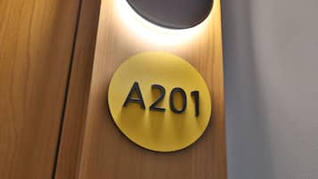 A circular sign with the number 'A201' on a wooden surface.