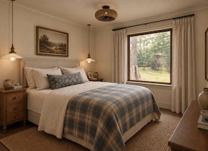 A bedroom with a large bed, bedside tables, a window with curtains, and a painting on the wall. - The Pecan House, A 3BR Restored Cottage in Woodville (Woodville)