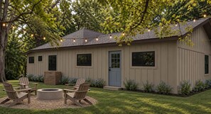A house with a deck, outdoor seating, and a fire pit. - The Pecan House, A 3BR Restored Cottage in Woodville (Woodville)