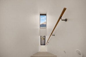 Eine Holztreppe mit Geländer führt zu einer Tür mit Blick auf die Berge.