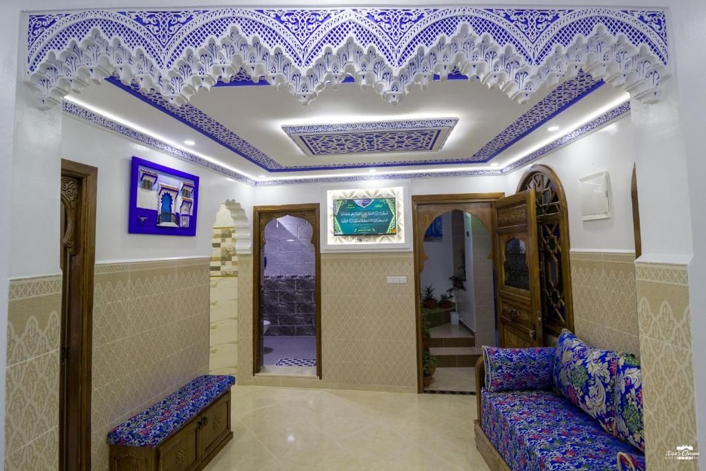 A room with a patterned ceiling, a bench, a sofa, and a framed picture on the wall.