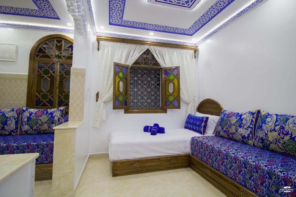 Una habitación con una cama, un sofá y un ventanal de detalles elaborados.