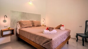 A bedroom with a large bed, two bedside tables, a chair, and wall-mounted lighting. - Lapas · Jungle House for 4 + Pool +AC · Walk to Beach · Cabuya (Cabuya)