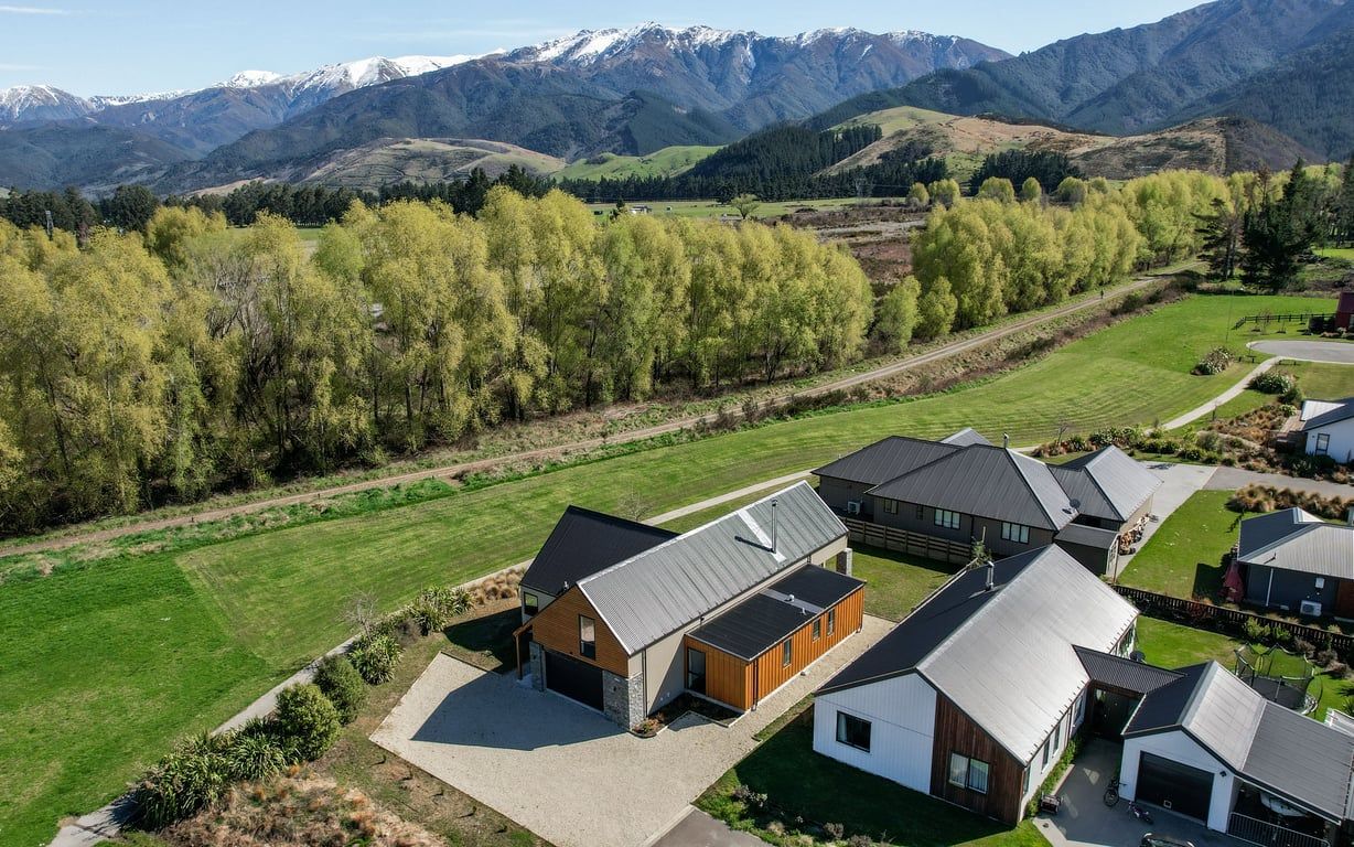 Zona residencial con casas modernas, una calle despejada y montañas al fondo.