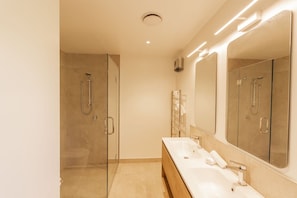A modern bathroom with a glass-enclosed shower, a wooden vanity with two sinks, and a large mirror. - Riverside | BBQ & Fireplace | Reserve - HS519D (Hanmer)