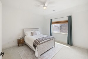 A bedroom with a bed, bedside table, lamp, and a ceiling fan. - 5BR Frisco Retreat Near Universal Kids Resort/PGA (Frisco)