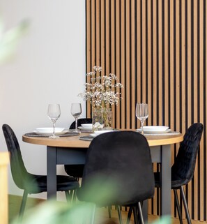Ein Esstisch mit Geschirr, Gläsern und einer Blumenvase.
