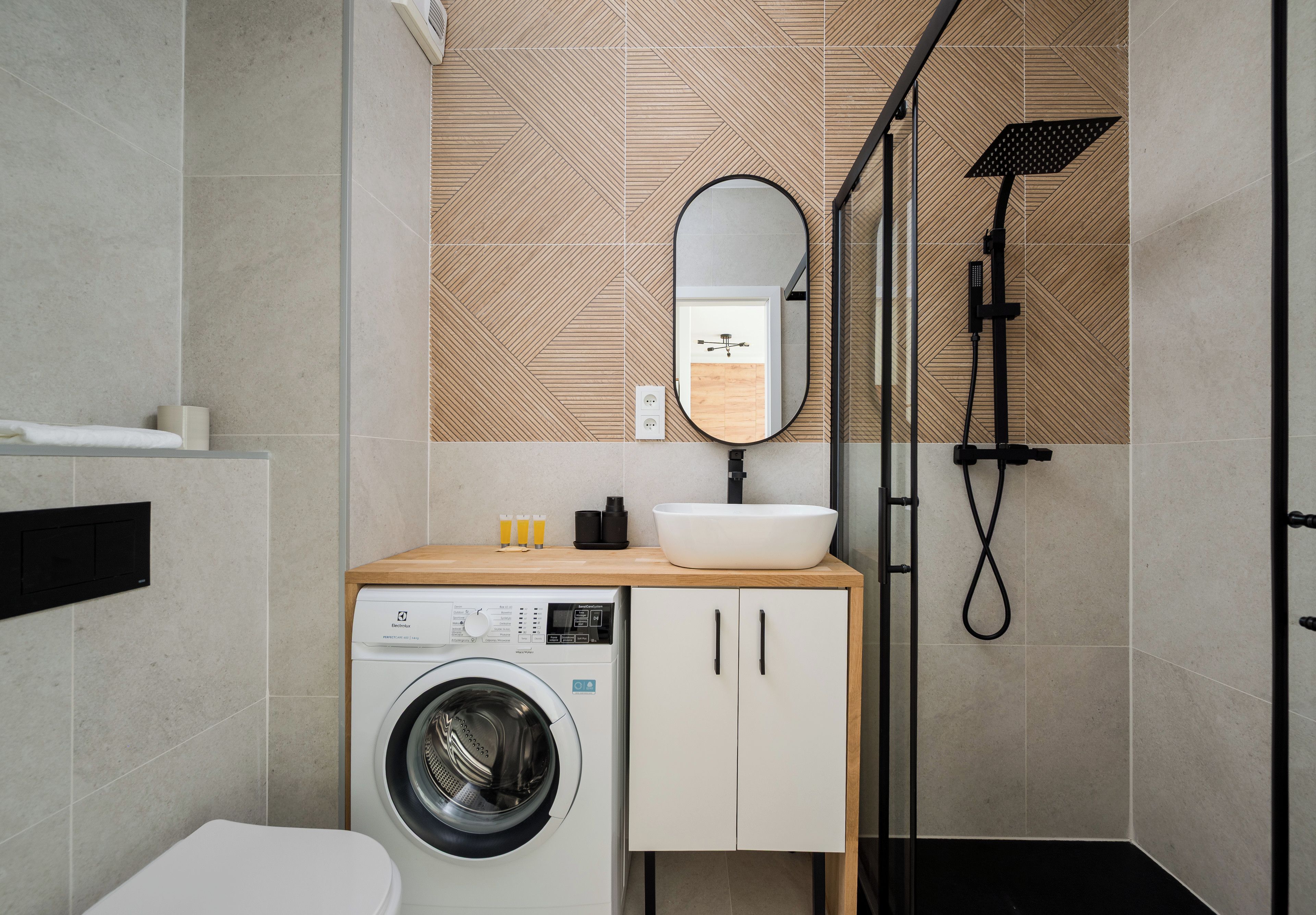 Un baño moderno con lavadora, lavamanos y ducha.