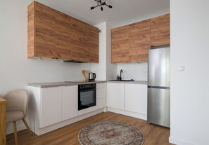 Een moderne keuken met houten kastjes, een roestvrijstalen koelkast en een inbouwoven.