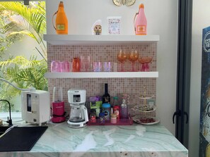 A kitchen counter with a coffee maker, a blender, and various kitchen items. - Pool House 311 by Diana (Jocotepec)