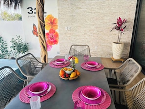 Un comedor con pared de ladrillo, un cartel con el número '31' y un mural de flores de hibisco.