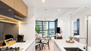 Une cuisine moderne avec un coin repas, de grandes fenêtres et une vue sur la ville.