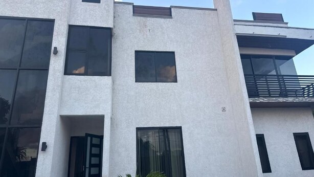 Un edificio a più piani con ampie finestre e un balcone.