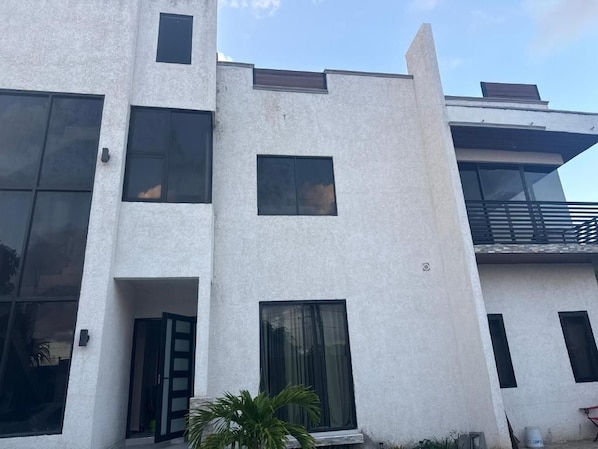 Un edificio de varios pisos con grandes ventanales y un balcón.