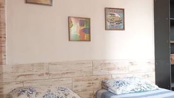 Habitación con dos camas, cabecero de madera y obra de arte en la pared.