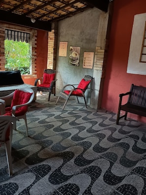 Un café acogedor con sillas de mimbre, piso estampado y pared de ladrillo.
