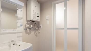 A modern bathroom with a white sink, mirror, and a large window.