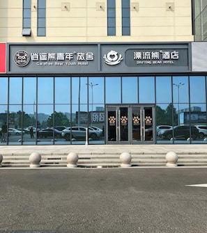 A hotel entrance with glass doors and a bear logo. - CAREFREE BEAR YOUTH HOSTEL-Sijiqing Qiao (Beijing)