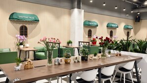 Een vergaderruimte met een lange tafel, witte stoelen en groene accenten.