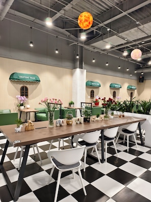 A conference room with a long table, white chairs, and green accents. - CAREFREE BEAR YOUTH HOSTEL-Sijiqing Qiao (Beijing)