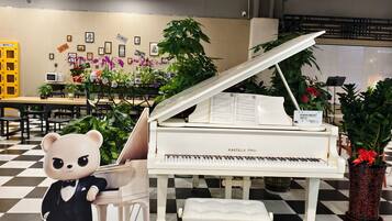 A room with a grand piano, a bear statue, and a checkered floor.