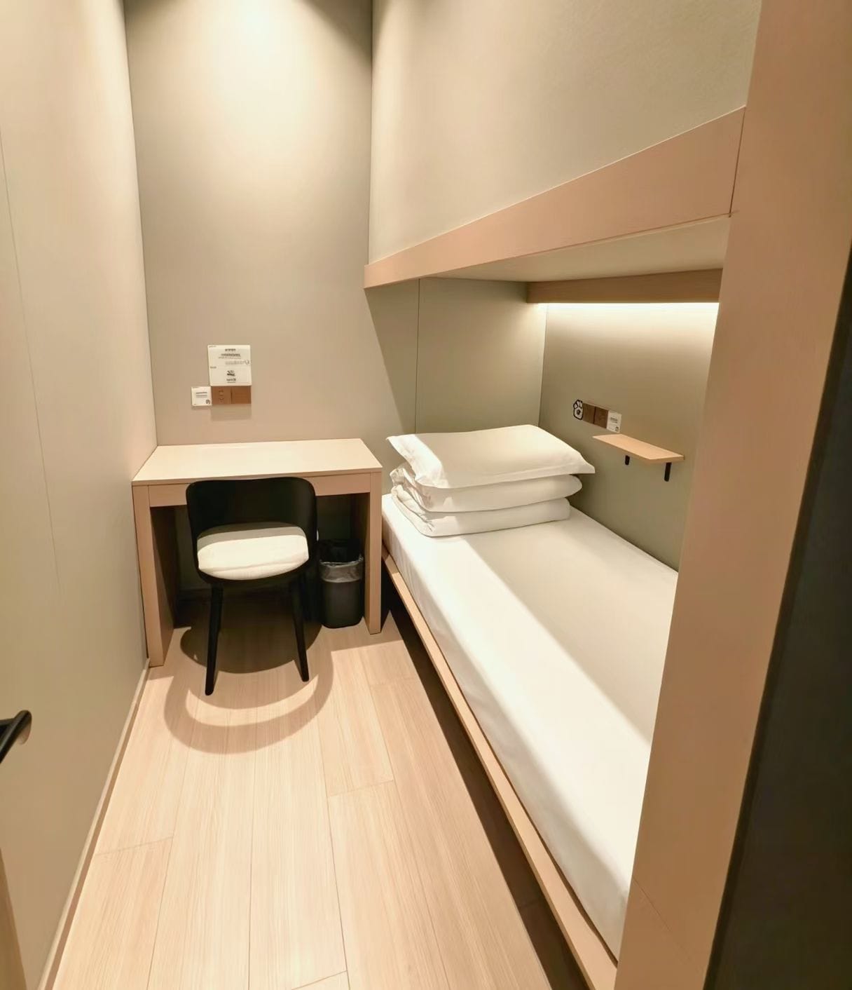 Ein kleines Zimmer mit Etagenbett, Schreibtisch und Stuhl.