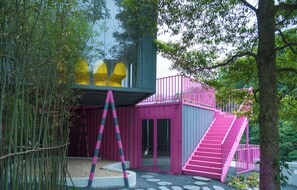 A pink and gray building with a staircase and a glass door.