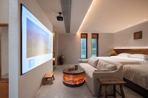 A modern hotel room with a large screen, a fireplace, a sofa, and two beds. - Yunfuli Qingcheng Housi (Chengdu)