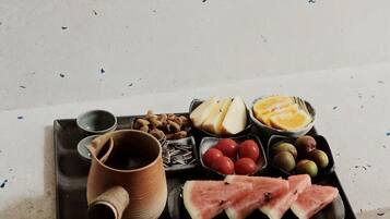 A tray with various food items including fruits, nuts, and a mug.