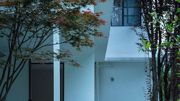 Un edificio con fachada blanca, una puerta y un pequeño letrero en la pared.