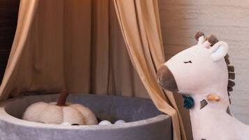 A room with a grey pet bed, a white stuffed toy, and a woven basket.