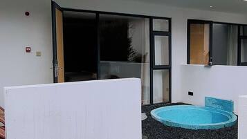A modern outdoor area with a swimming pool, a sliding glass door, and a white partition.