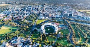 Une vue aérienne d’une ville avec un grand stade entouré d’espaces verts et de routes.