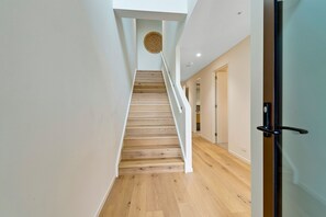 Un escalier avec des marches en bois menant à un palier orné d’une décoration murale circulaire.