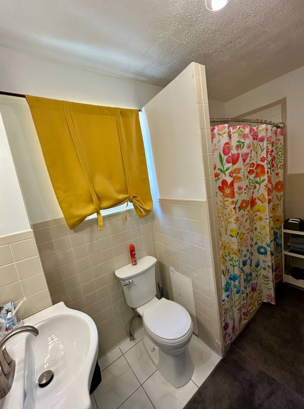 A bathroom with a white sink, toilet, and shower curtain.
