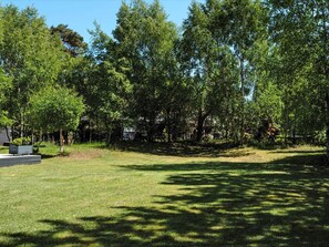 A park with a grassy area, trees, and a bench. - 4 Person Holiday Home in Hojby (Hojby)
