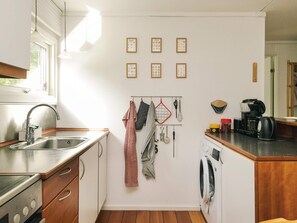 A compact kitchen with a sink, stove, and a coffee maker. - 4 Person Holiday Home in Hojby (Hojby)