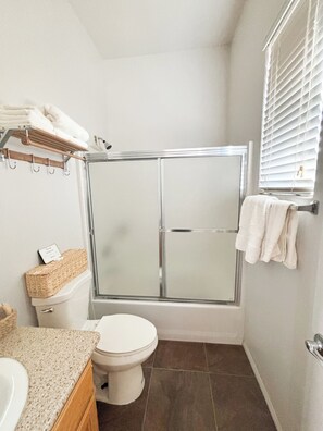 A bathroom with a glass-enclosed shower, a toilet, and a sink. - Cozy Casita in wonderful Indio with large outdoor space, near festival grounds. (Indio)