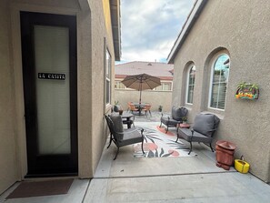 A patio area with outdoor furniture, a welcome sign, and a door labeled 'LA CASITA'. - Cozy Casita in wonderful Indio with large outdoor space, near festival grounds. (Indio)