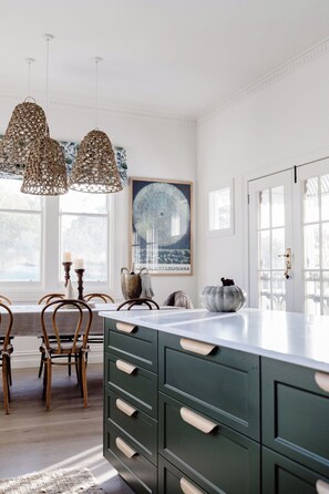 A kitchen with a large island, pendant lights, and a dining area with wooden chairs. - Luxury and comfort in the heart of Dunkeld, with the Grampians at your doorstep! (Dunkeld)