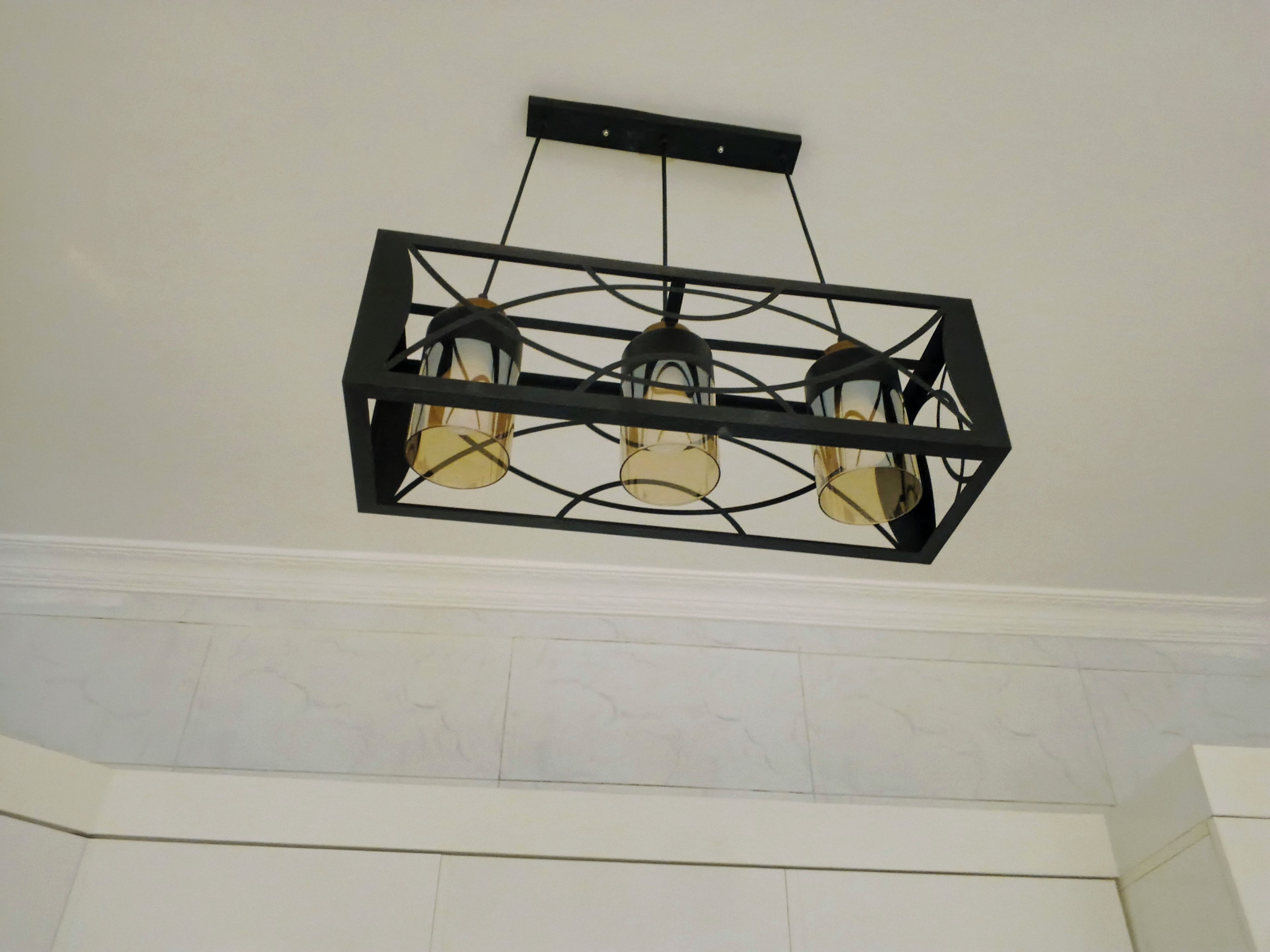 Un luminaire fixé au plafond, doté de trois ampoules.