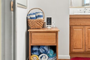A wooden shelf with a basket of folded towels and a chalkboard sign. - The Red Lake House | Beach & Dock Access (Chelan)