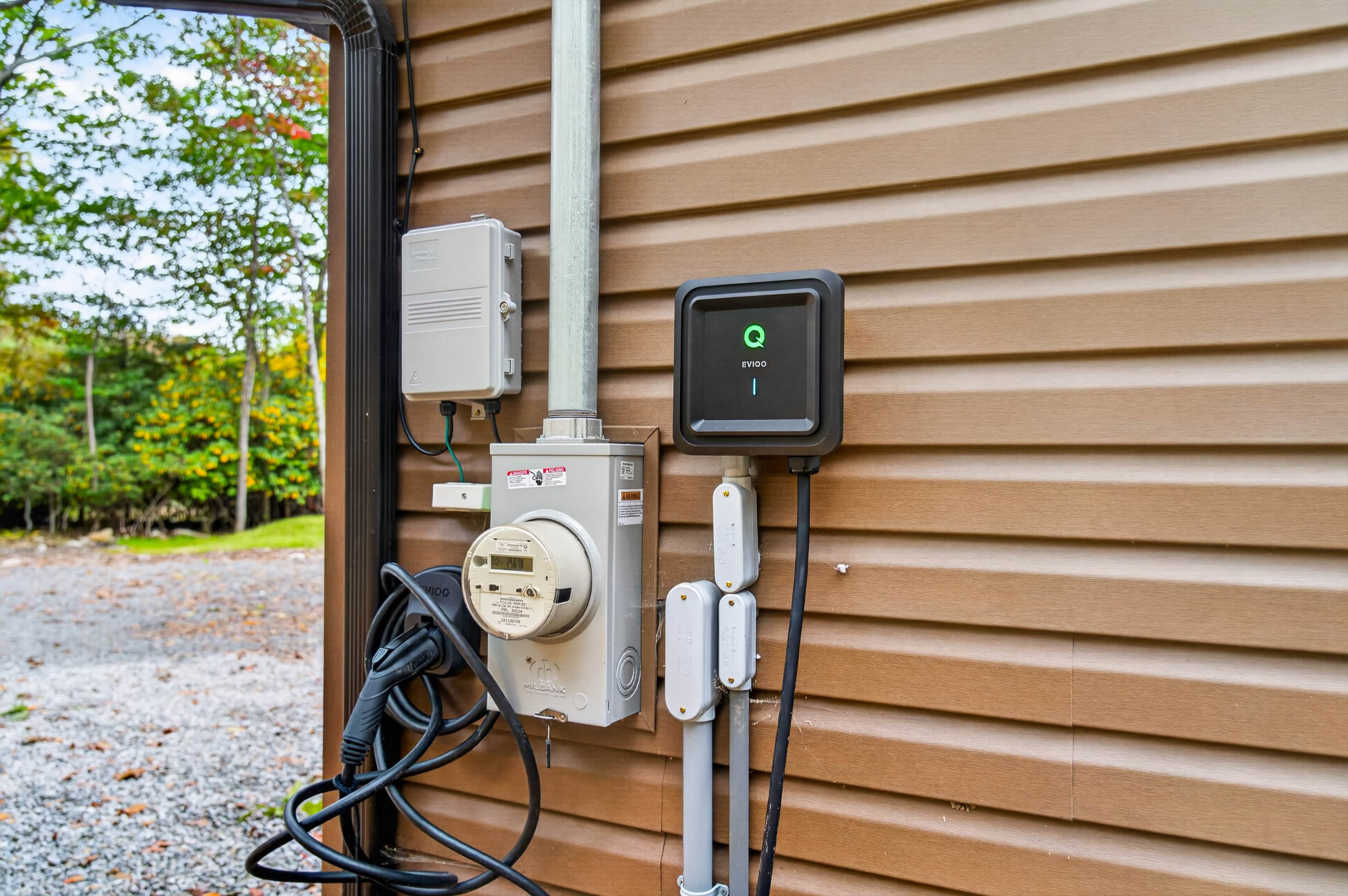 Een elektrische schakelkast met diverse meters en apparaten bevestigd aan een houten wand.
