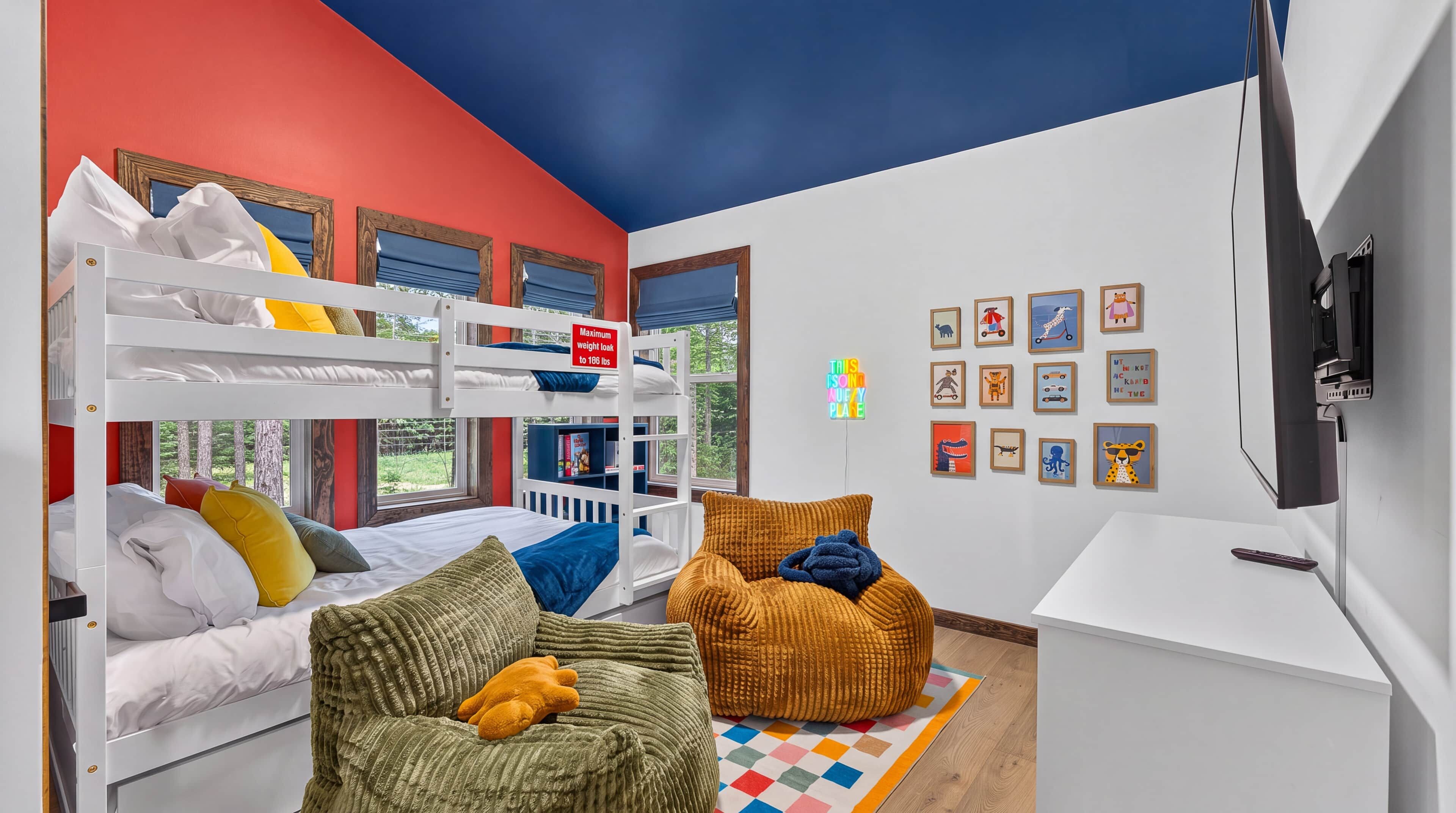 Una habitación infantil con literas, un escritorio y un televisor.