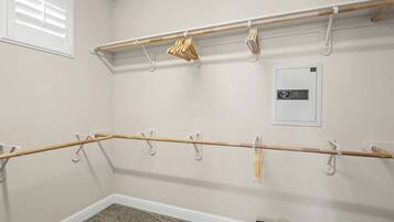 Una habitación con un perchero de madera, un calentador de pared y un bolso en el suelo.