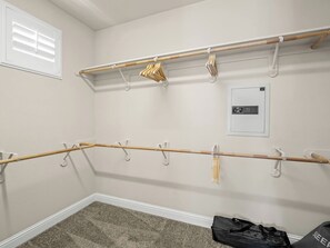 Una stanza con un appendiabiti in legno, un termosifone a parete e una borsa sul pavimento.