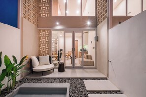 Een modern interieur met een zithoek, een kleine tafel en een waterpartij.