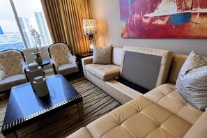 A hotel room with a sofa set, a coffee table, and a painting on the wall. - New Year’s Eve in Las Vegas — Stay on the Strip (Las Vegas)