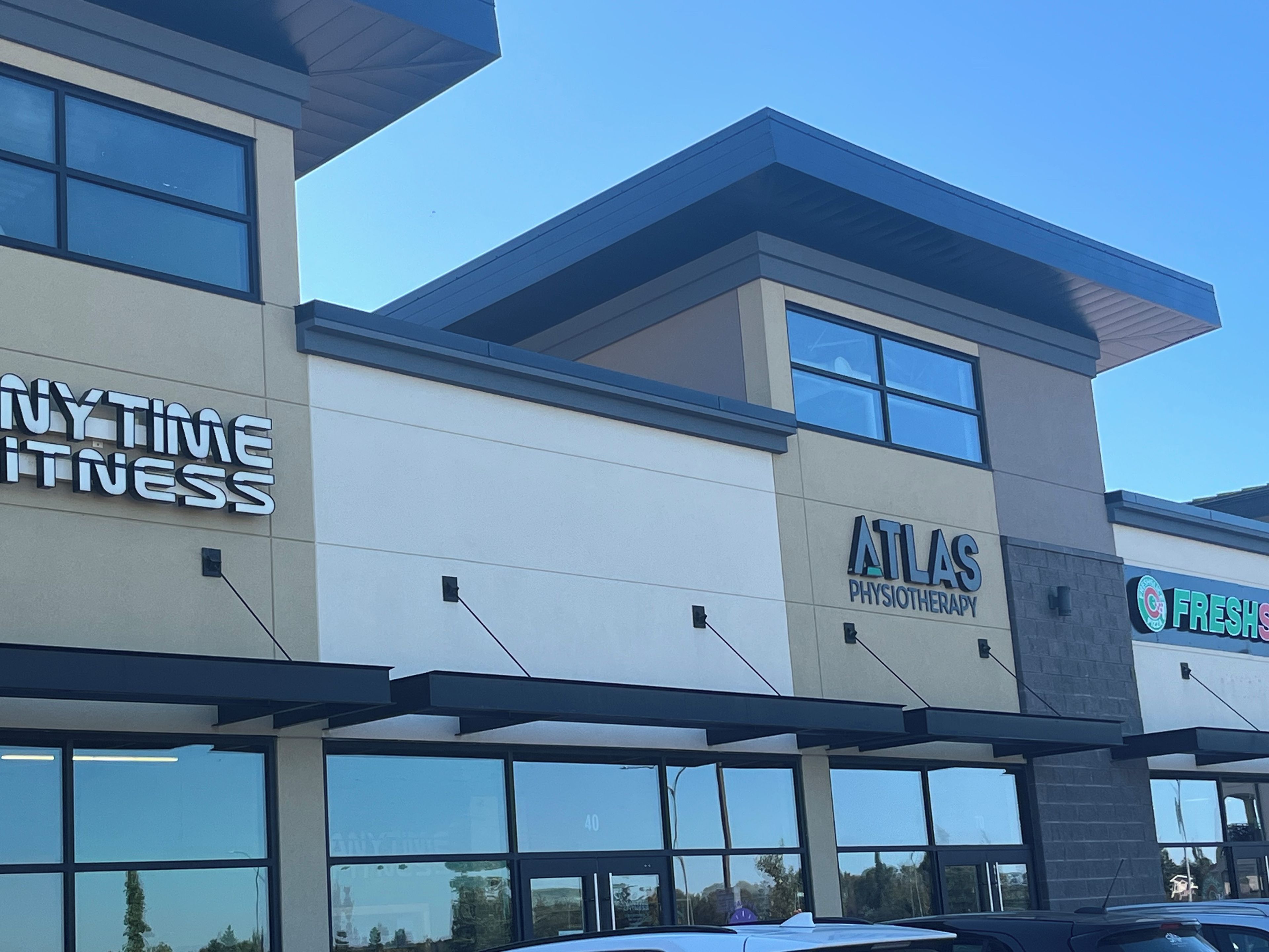 Un bâtiment portant les enseignes « ANYTIME FITNESS » et « ATLAS PHYSIOTHERAPY ».