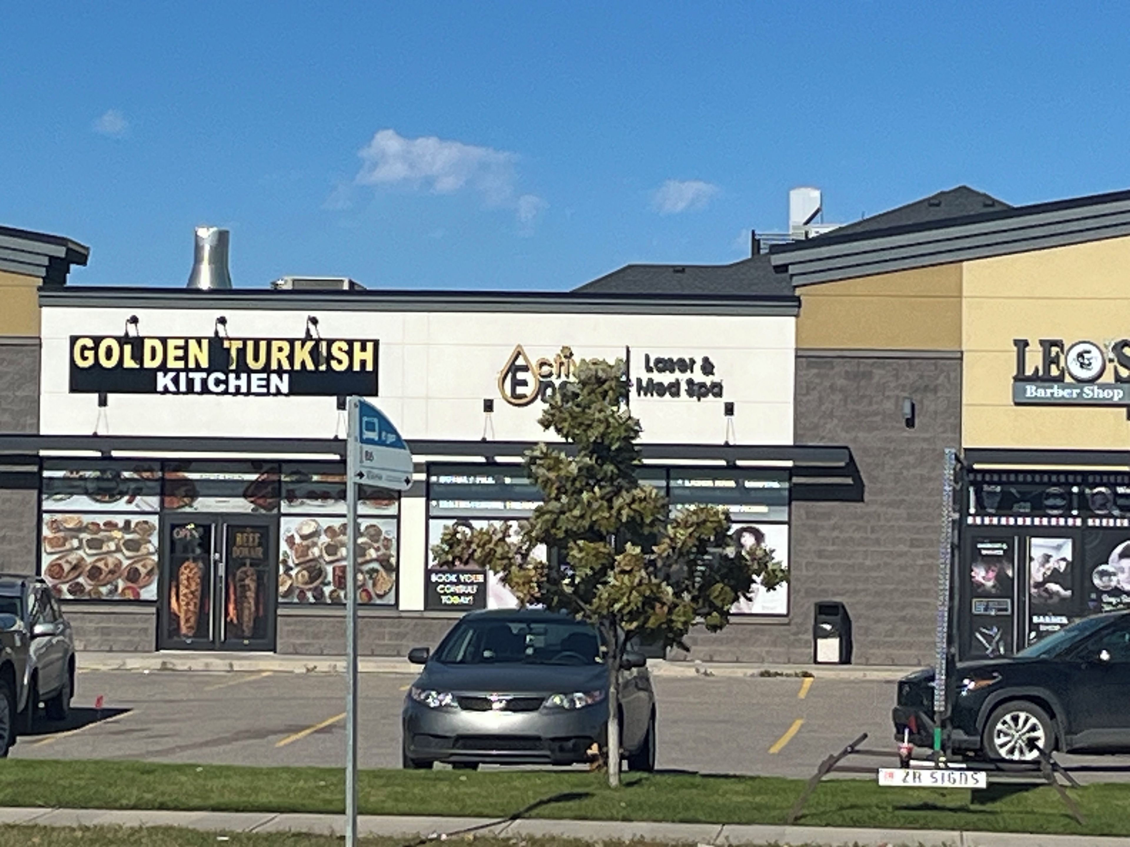 A building with a sign for 'Golden Turkish Kitchen' and a barber shop.